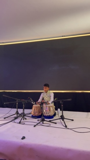 Student in a white kurta performing a tabla solo