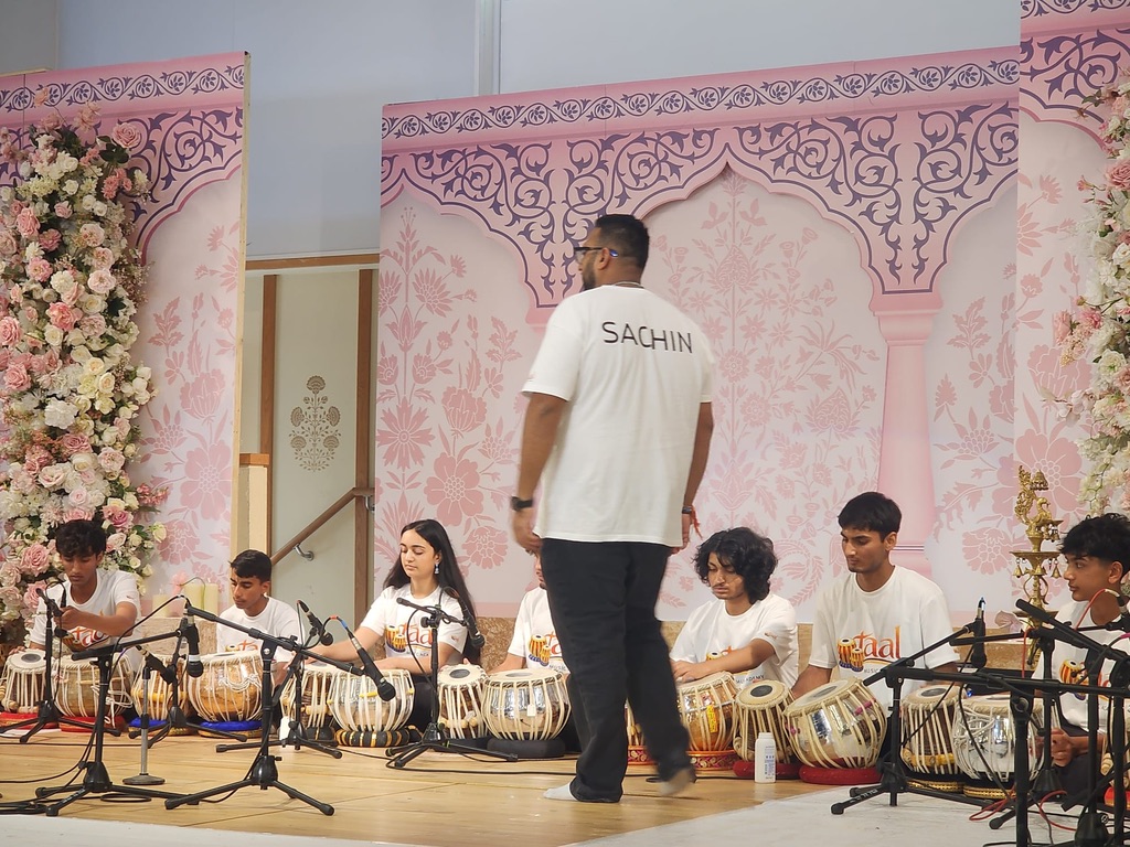Sachin Khetani directing a large student tabla ensemble at a cultural celebration