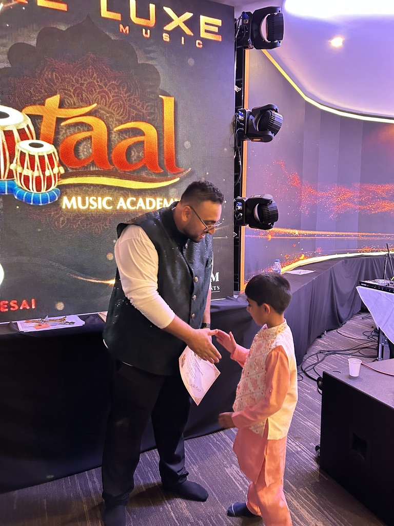 Sachin Khetani presenting a certificate to a young Taal Music Academy student